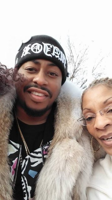 Two people in winter coats and glasses taking a selfie outdoors