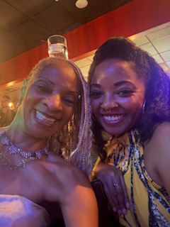 Two smiling women together in a warmly lit room