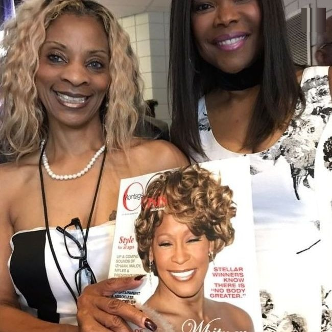 Two readers holding up the Whitney Houston tribute issue of Oasis Montagé