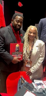 A man and a woman smiling together at a book table, holding up a copy of The Legendary Mississippi