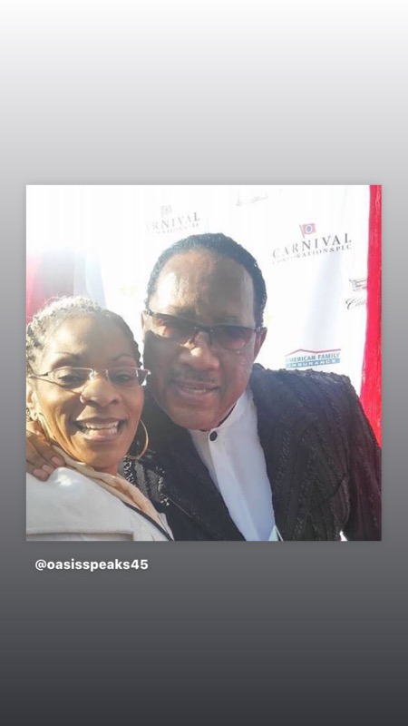 A joyful pair posing arm in arm in front of a Carnival and American Family Insurance step-and-repeat backdrop