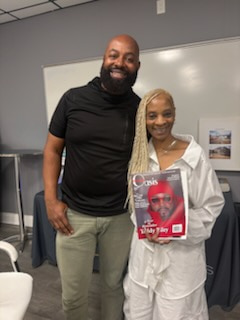 Two smiling people holding a copy of Rolling Out magazine